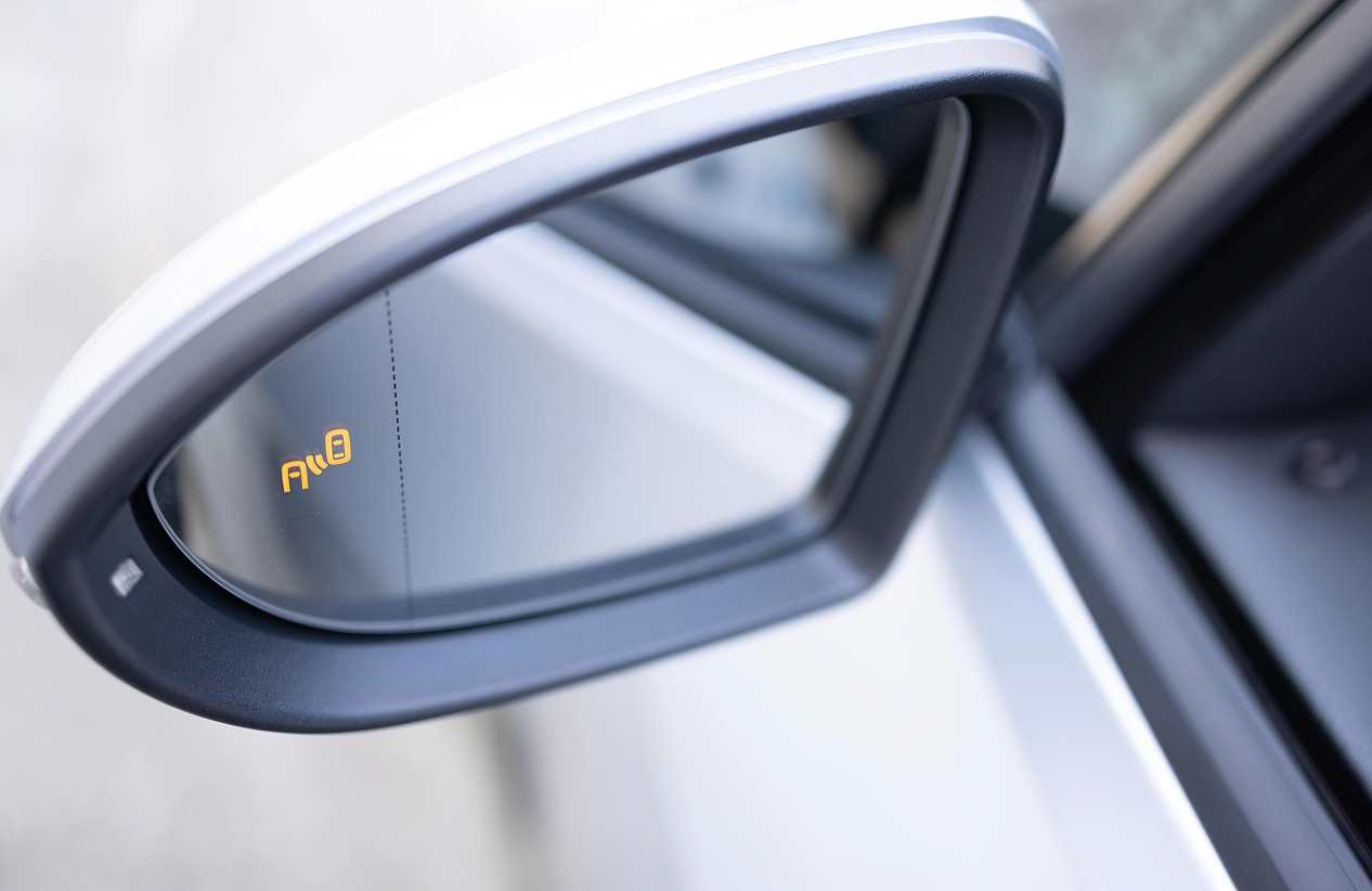 side view car mirror showing car in next lane indicator