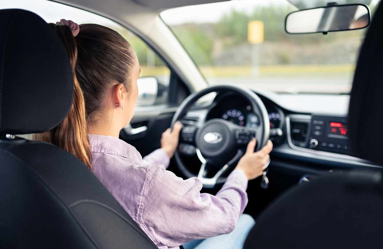 backseat perspective of female driving a car down the road