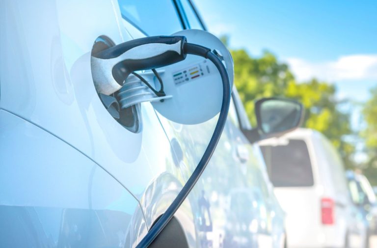 White electric vehicle charging at a station