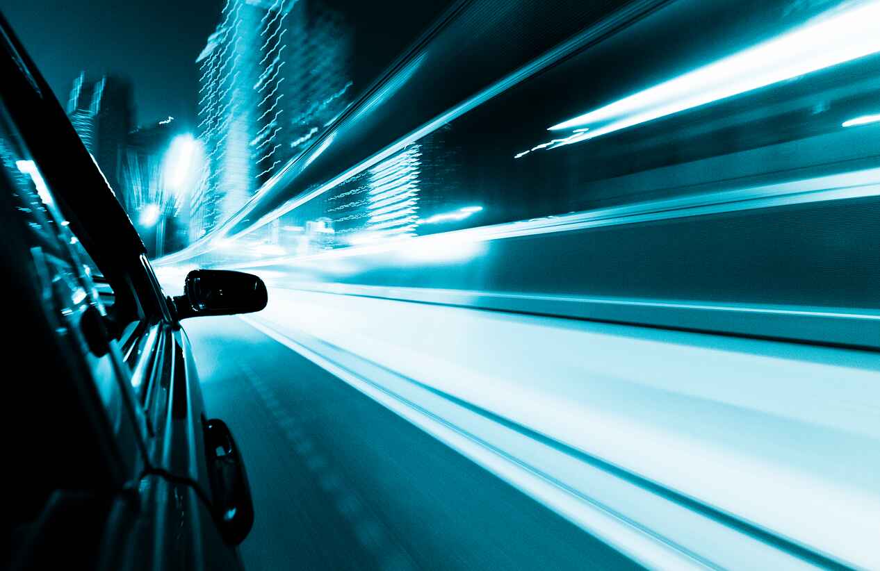 motion shot of a car driving down the road with buildings and other cars out of focus