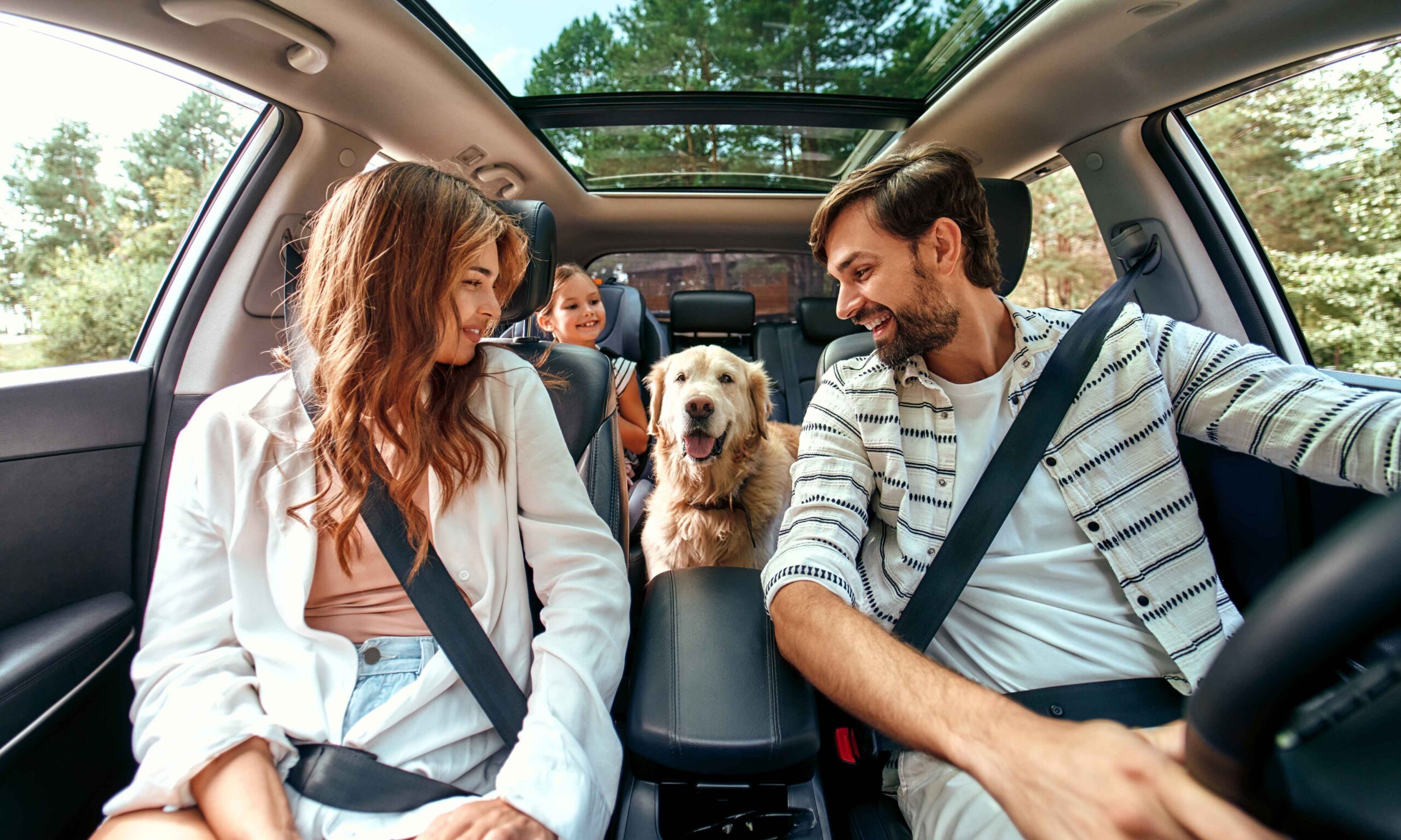 Family in car with child and dog