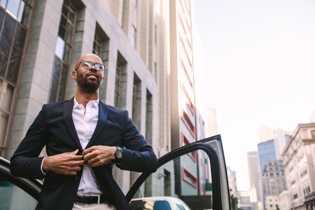 man getting out of car buttoning jacket