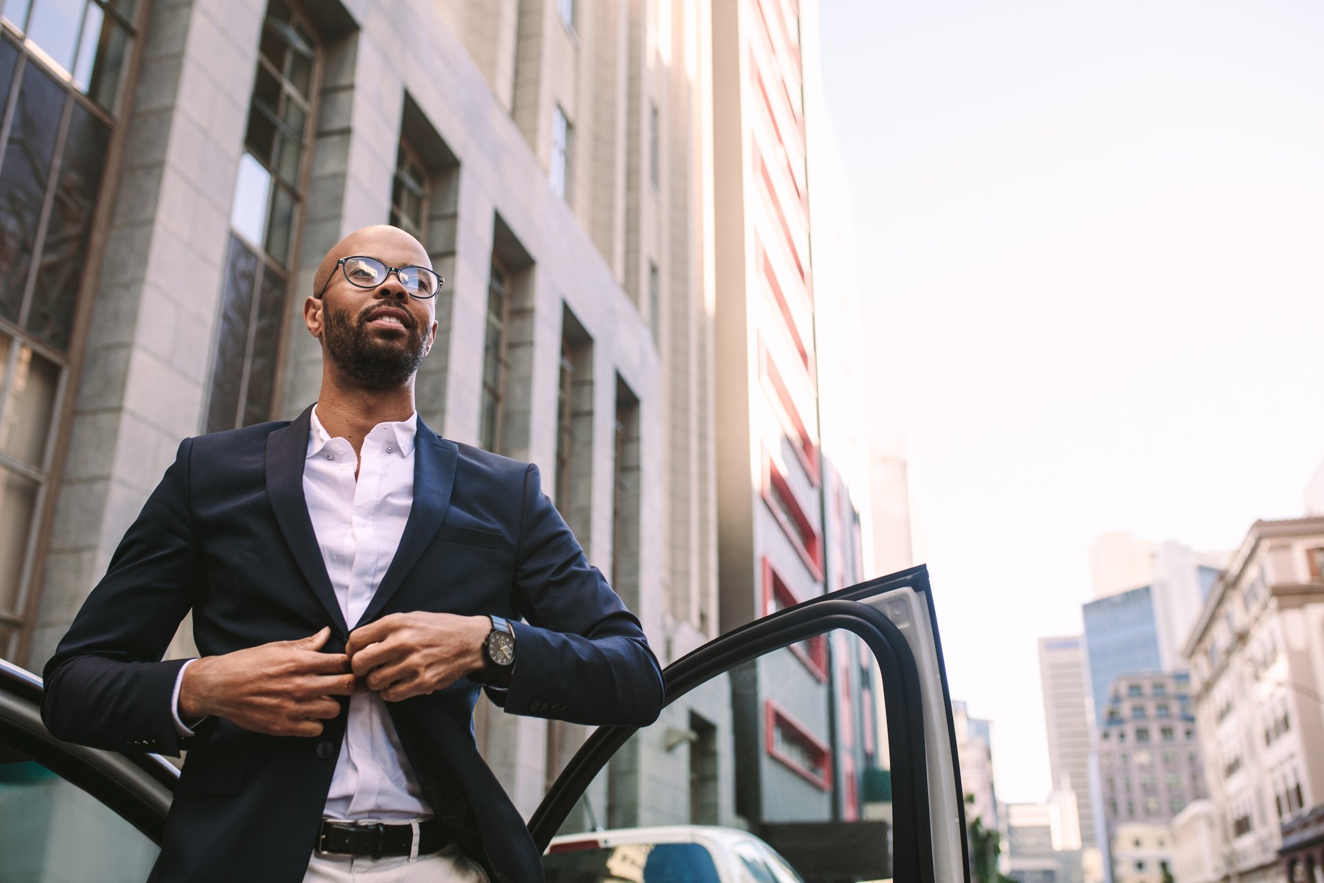 man getting out of car buttoning jacket