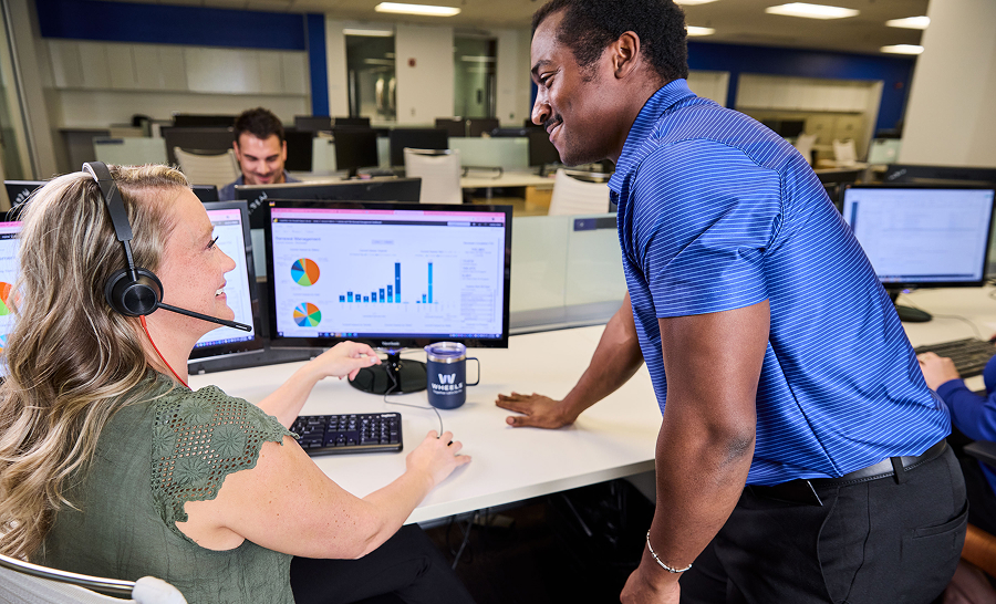 two employees at desk looking at computer