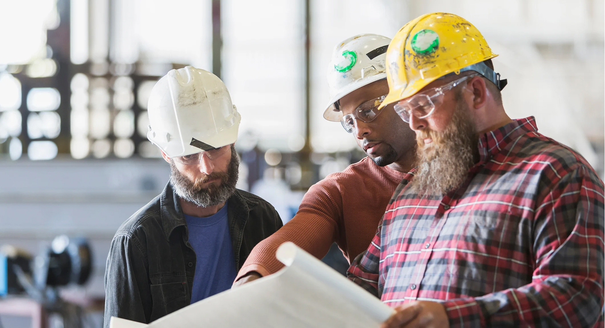 Three construction workers with hard hats