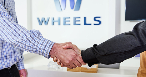 two people shaking hands at the wheels office