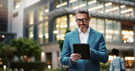 Business man walking outside with a tablet