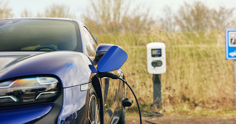 photo of a porche at an ev charging station in a rural area