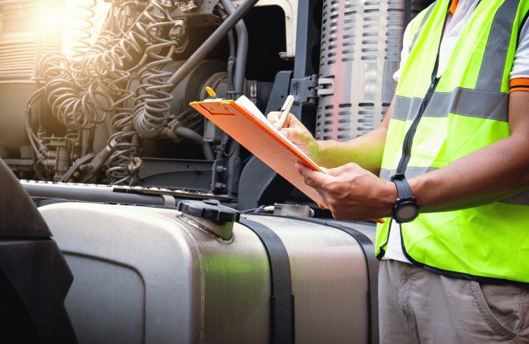 person holding a clipboard next to a truck