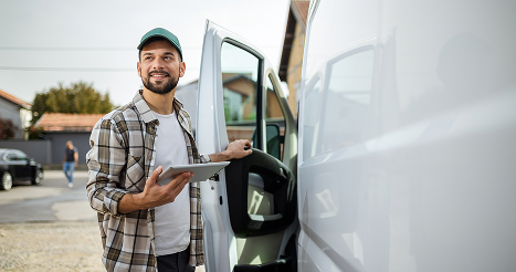 man with tablet getting into white work van