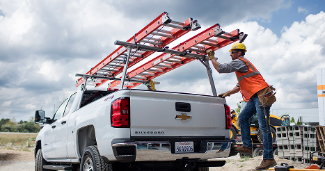 Working getting down from white work truck with ladders on top