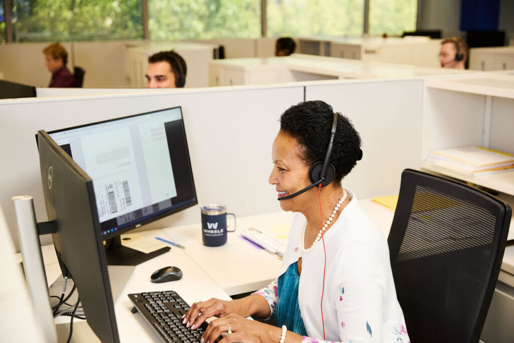 Wheels employee at desk with headphones