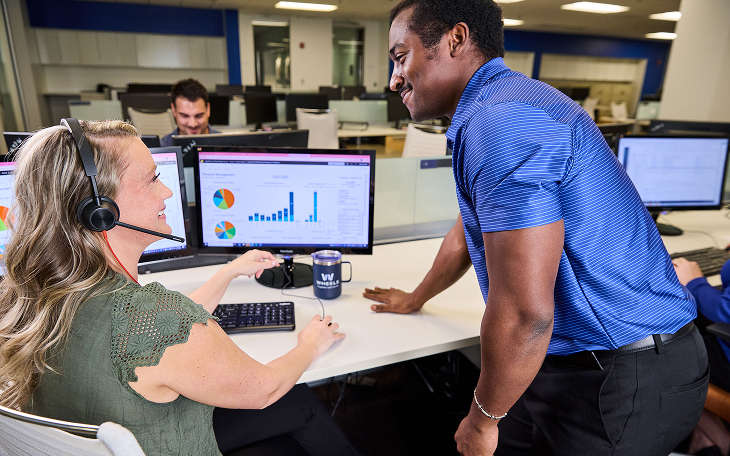 Two wheels employees talking look at computer
