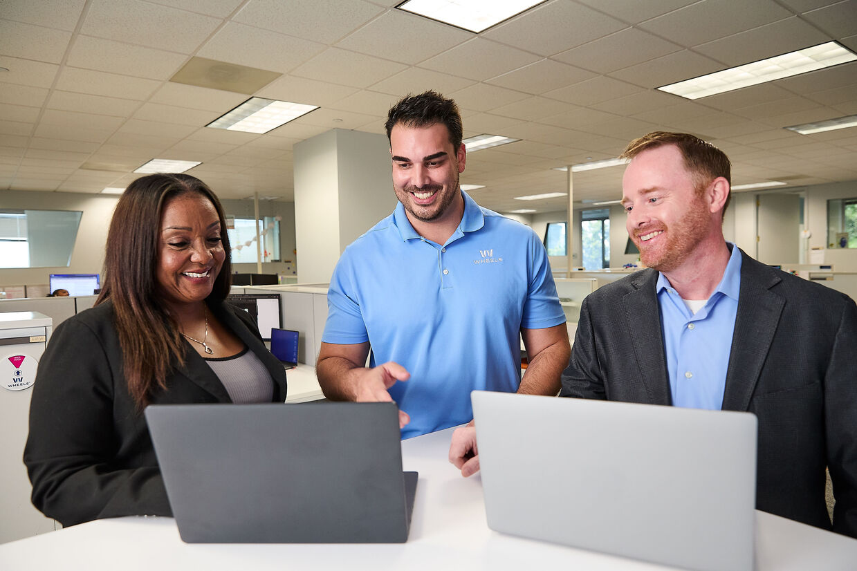 Three Wheels employees looking at two laptops