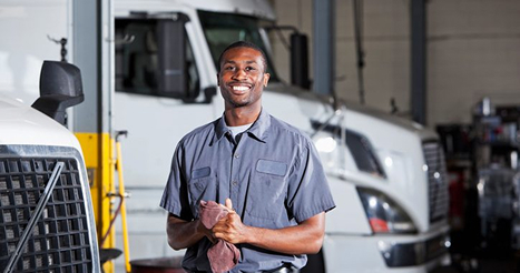 maintenance worker standing in front of semi truck