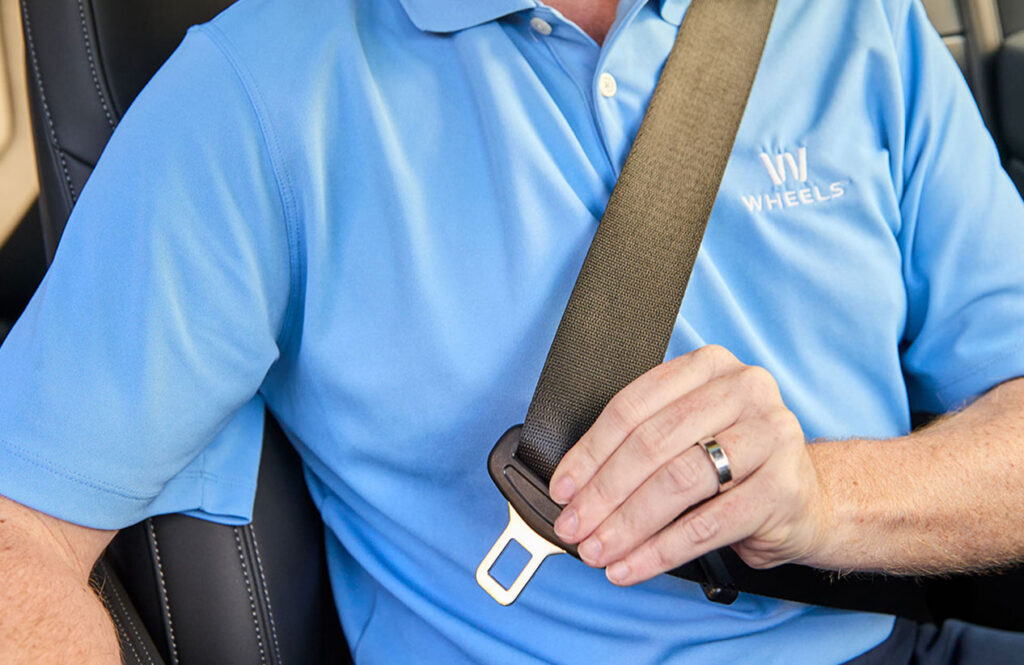man putting on seat belt