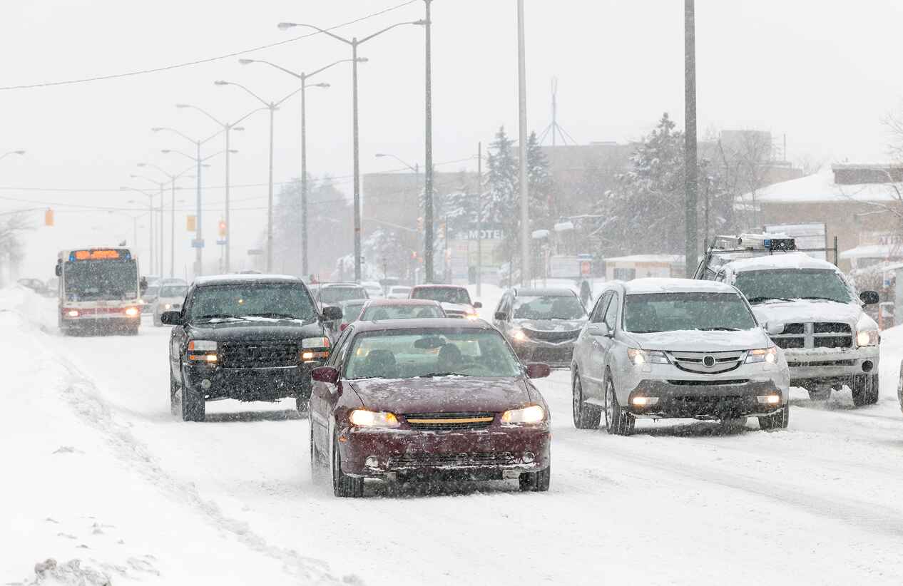 cars driving down a busy snowy multi-lane road