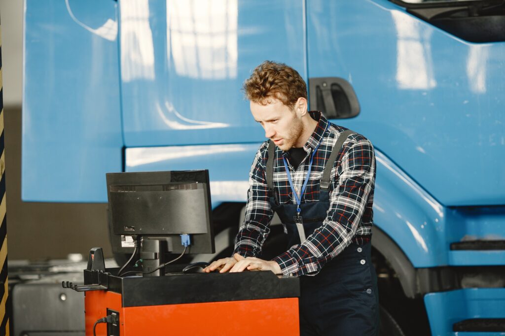 Garage technician working at computer in maintenance garage
