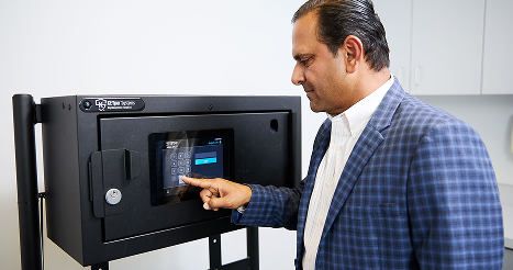 man in a suit punching in a code to get into a lockbox