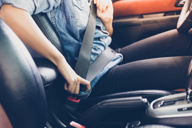 female driver buckling her seatbelt